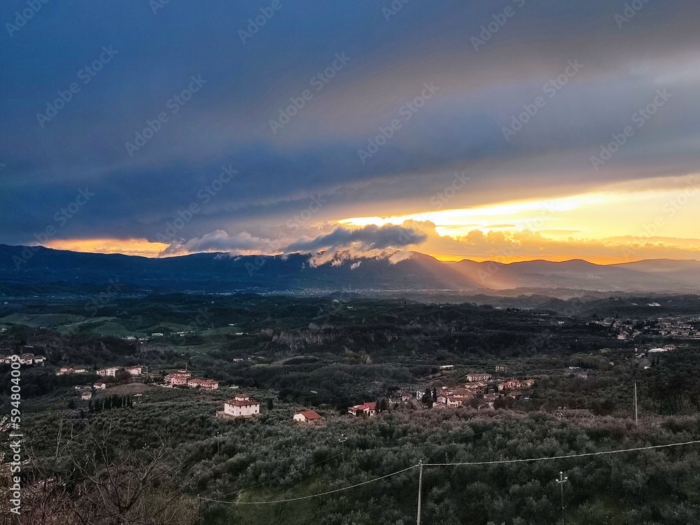 Overcast sky above the Valdarno countryside at sunset with the Chianti hills on the horizon, in Tuscany, Italy. Horizontal