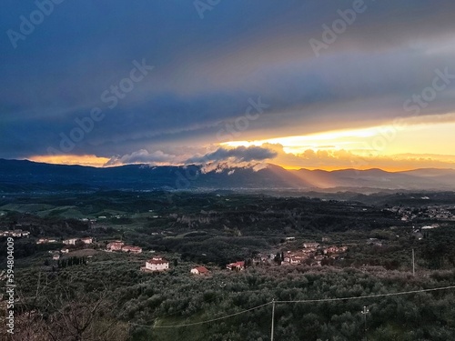Overcast sky above the Valdarno countryside at sunset with the Chianti hills on the horizon, in Tuscany, Italy. Horizontal
