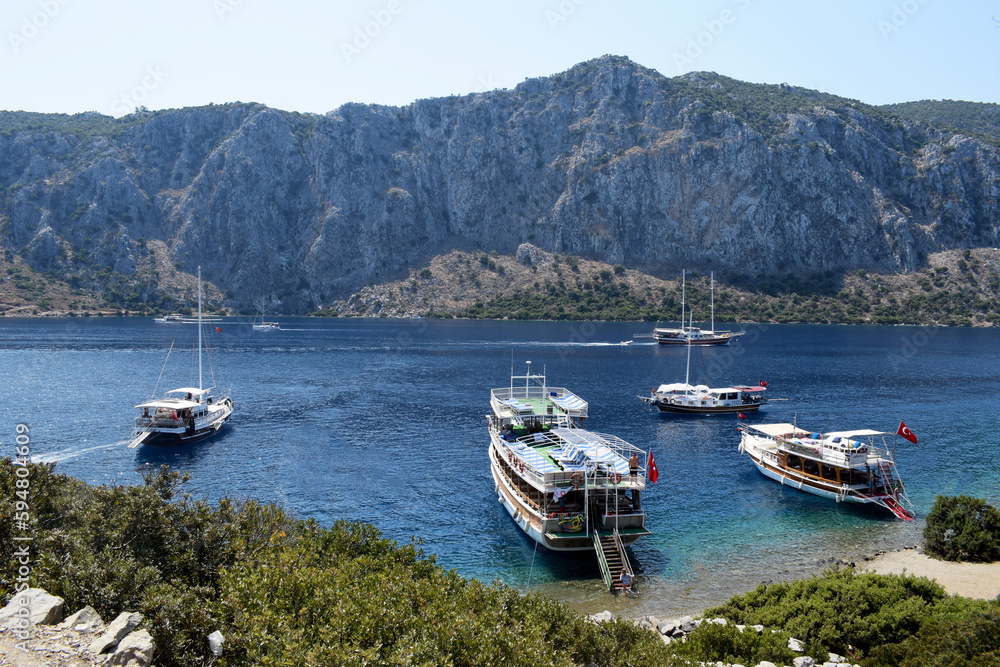 tourist ships in the bay among the mountains. Marmaris Kamelya Adasında Tarihi Manastır