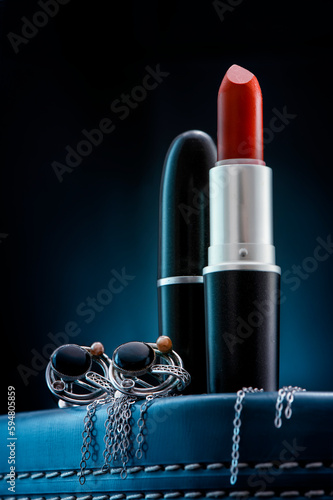 Makeup, Lipsticks and Jewelry on the dark blue background