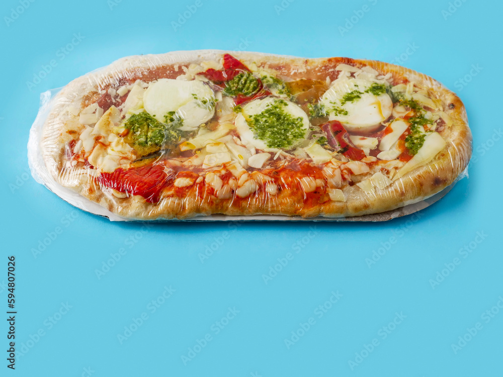 Italian style uncooked pizza on blue color background. Premium product with high quality ingredients.