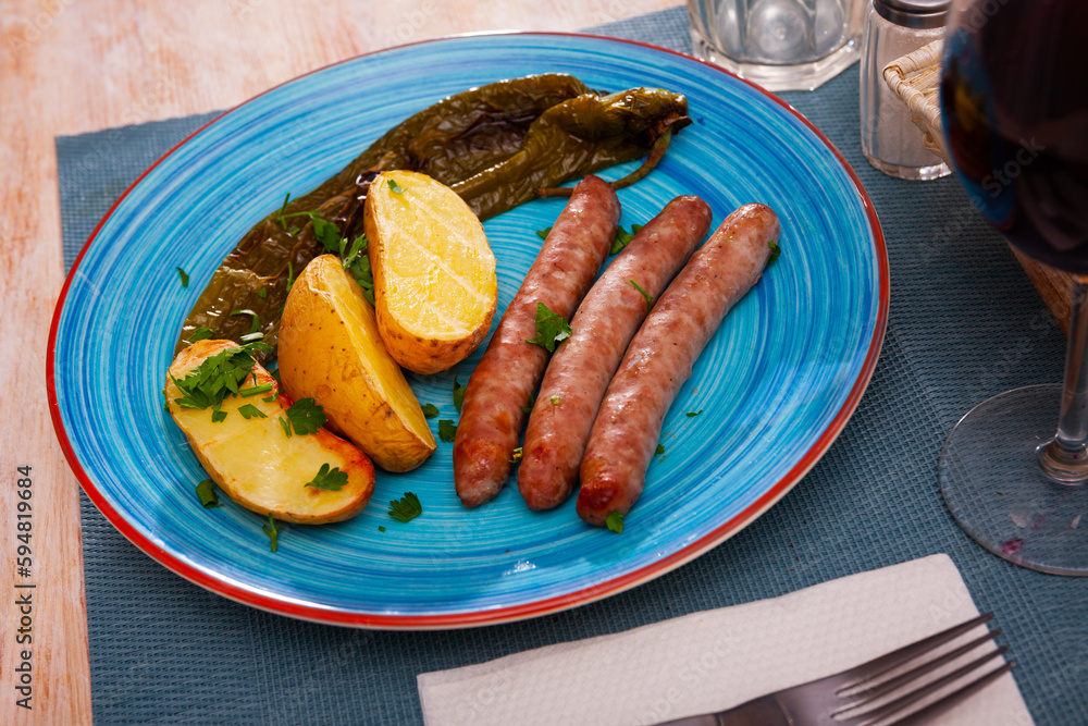 Delicious sausages and fried potatoes with stewed peppers