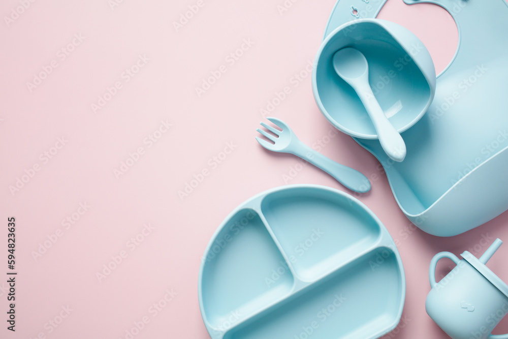Silicone baby feeding set on pink background. Toddler led weaning supplies, divided plate, bowl with suction, silicone bib, sippy cup Silicone baby feeding set on pink background. Toddler led weaning supplies, divided plate, bowl with suction, silicone bib, sippy cup