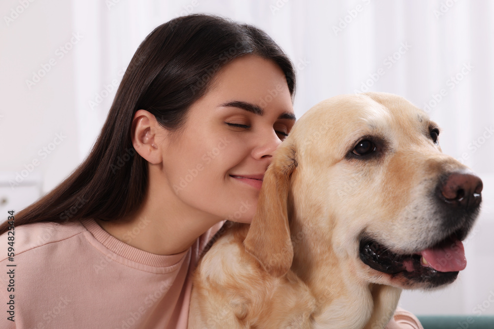 Happy woman with cute Labrador Retriever at home, closeup Happy woman with cute Labrador Retriever at home, closeup