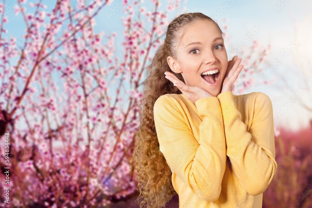 Happy young woman with a flowering tree on the background Happy young woman with a flowering tree on the background