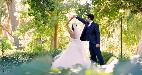 Wedding, dance and love with a married couple outdoor in a garden together dancing in tradition after a ceremony. Happy, celebration or relationship with a husband and wife having fun in a park photo