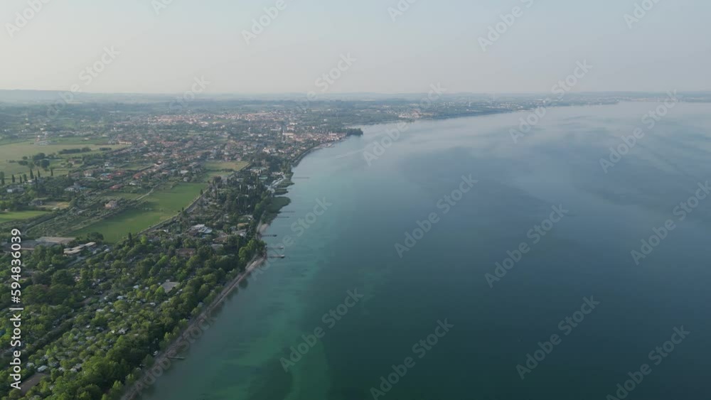 Tranquility Scene Of Lake Garda And City By The Bay At Daytime In Northern Italy. aerial, wide shot Tranquility Scene Of Lake Garda And City By The Bay At Daytime In Northern Italy. aerial, wide shot
