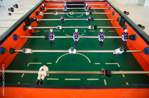 A foosball table is a recreational game symbolizing entertainment  skill  and socializing. It represents teamwork  competition  and the joy of play  and is often associated with bar and culture