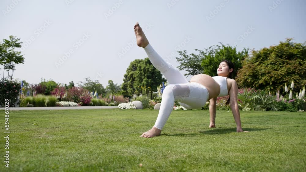slow motion of Pregnant young asian woman exercising on the lawn doing yoga poses at spring sunny day