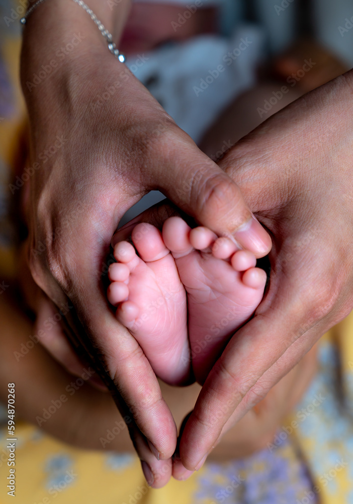 Newborn baby feet in female hands - obrazy, fototapety, plakaty 