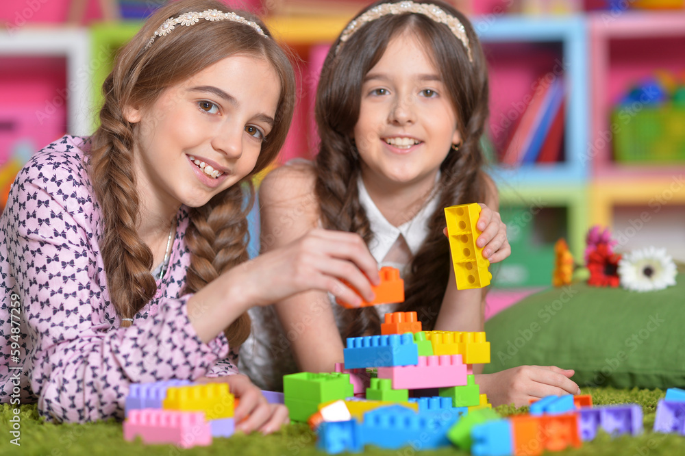 Two girls playing with colorful plastic blocks Two girls playing with colorful plastic blocks