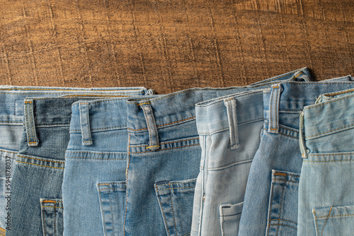 Lots of jeans pants, closeup. Denim background. The concept of buying, selling, shopping and trendy modern clothes