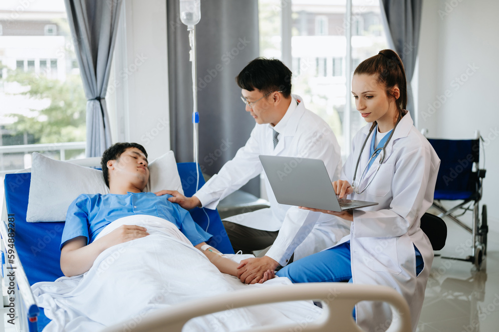 Obraz premium Two doctors talking to a patient lying in his bed with receiving saline solution in hospital .