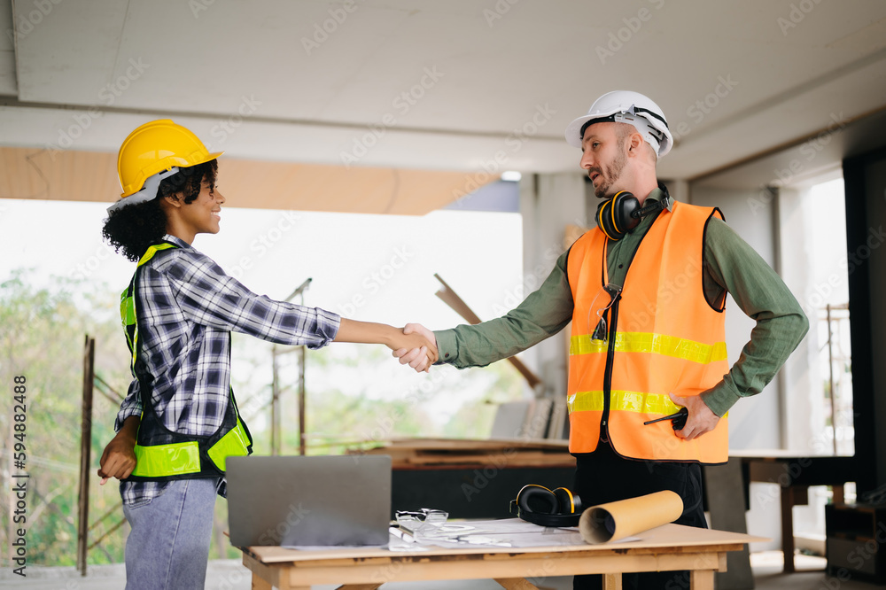 Engineer and contractor join hands after signing contract,They are having a modern building project together. successful cooperation concept.. Engineer and contractor join hands after signing contract,They are having a modern building project together. successful cooperation concept..