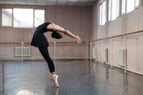 Asian woman dancing in ballet class. Bending in the back. photo