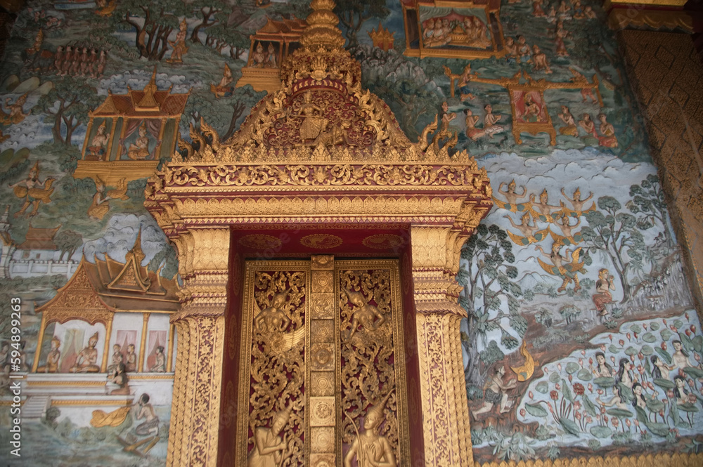 Entrance door with beautiful sculpture and stucco at Sim or Church architecture of Lan Xang style, there is a mural at Wat Mahathat or Wat That Noi 