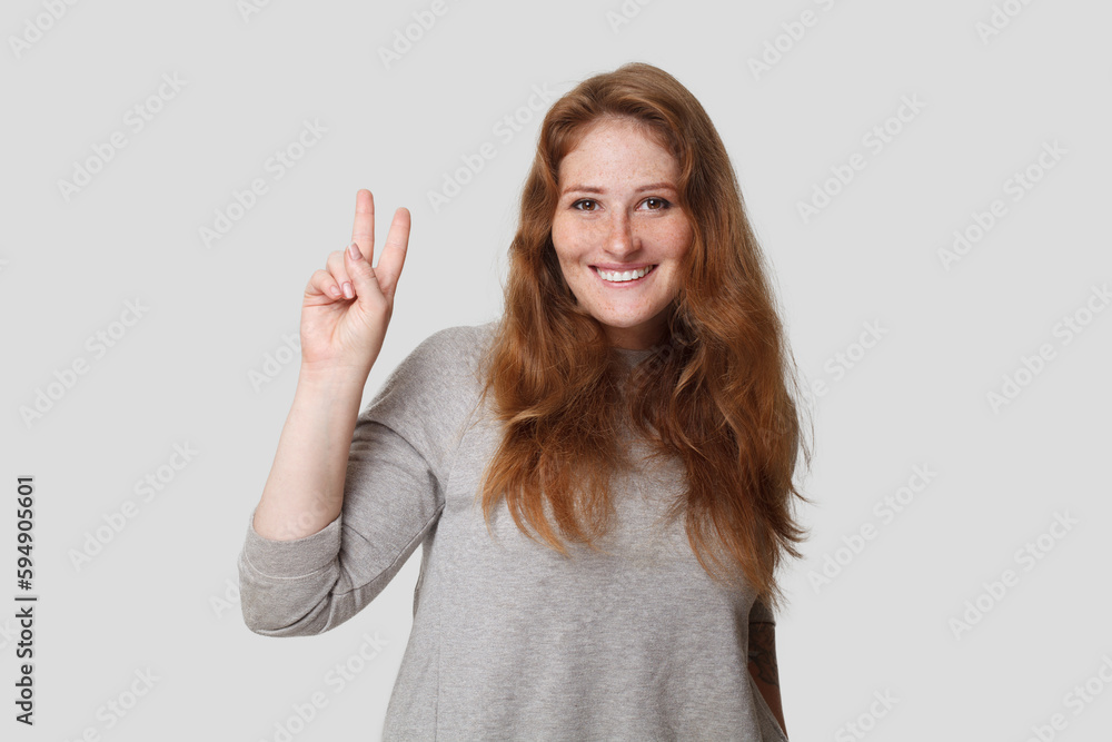 Cute friendly positive woman showing two finger on white background Cute friendly positive woman showing two finger on white background