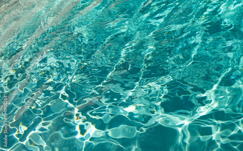 photo of defocused swimming pool water background. defocused pool water background.