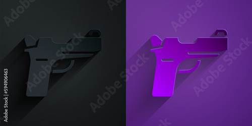 Paper cut Pistol or gun icon isolated on black on purple background. Police or military handgun. Small firearm. Paper art style. Vector