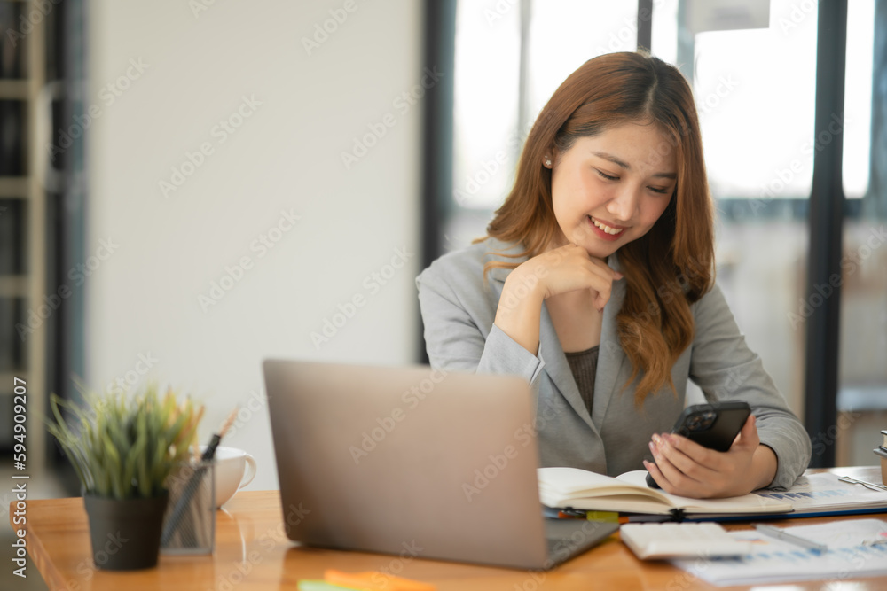 Asian businesswoman holding notebook about business, spending money Asian businesswoman holding notebook about business, spending money