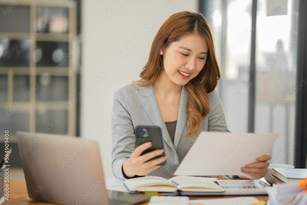 Asian businesswoman holding notebook about business, spending money Asian businesswoman holding notebook about business, spending money