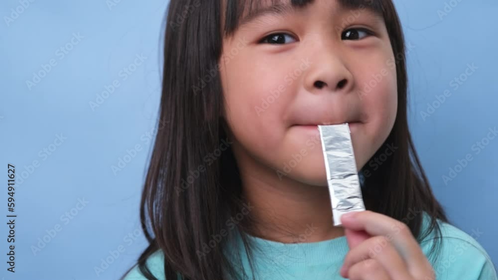 Little asian girl covering her mouth to smell the bad breath. Child girl checking breath with her hands. Oral health problems or dental care concept. Little asian girl covering her mouth to smell the bad breath. Child girl checking breath with her hands. Oral health problems or dental care concept.