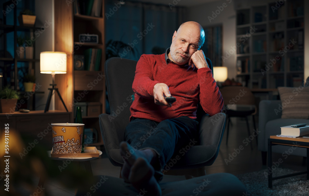 Bored senior man watching TV at night Bored senior man watching TV at night