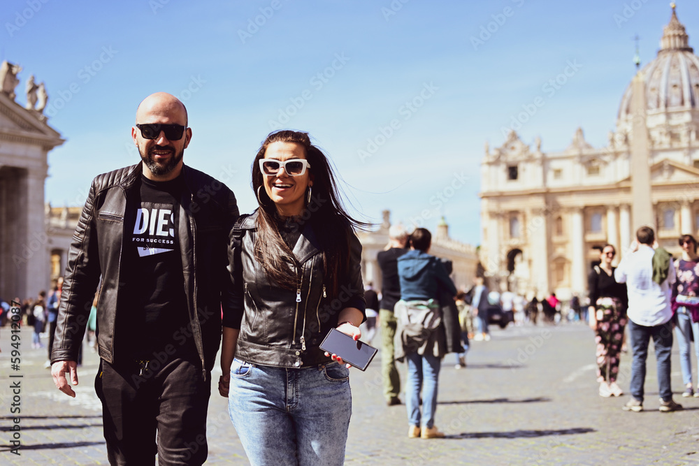Happy smiling beautiful Tourists couple traveling at Rome, Italy, poses and making photos in front of Vatican City at, Rome, Italy.Concept of Italian gastronomy and travel. Italian couple having Happy smiling beautiful Tourists couple traveling at Rome, Italy, poses and making photos in front of Vatican City at, Rome, Italy.Concept of Italian gastronomy and travel. Italian couple having