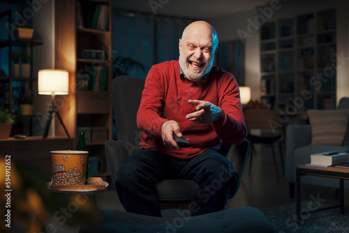 Happy senior man watching TV at night © StockPhotoPro