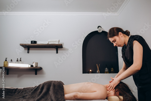 massage of neck for woman in spa salon.