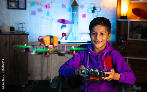 Excited indian kid celebrating after successfully test flying small drone project - concept of innovation, intelligence and smart child.