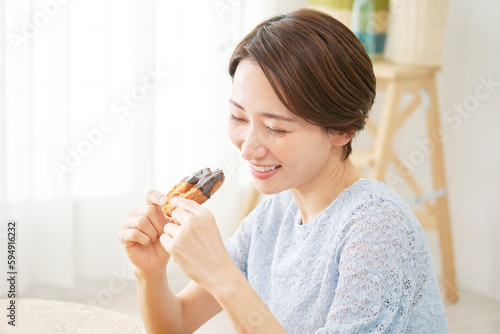 自宅でドーナツを食べる女性