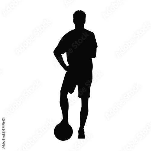 Professional football player silhouette stands straight with his foot on the ball and his arms folded on his chest