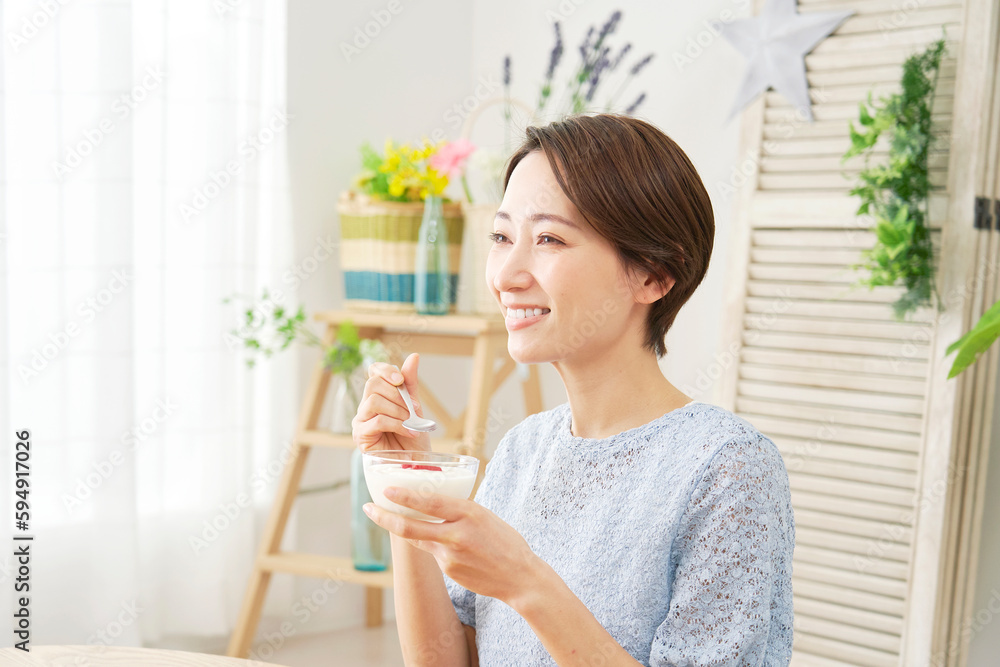 自宅でヨーグルトを食べる女性 自宅でヨーグルトを食べる女性