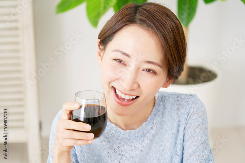 自宅でアイスコーヒを飲む女性