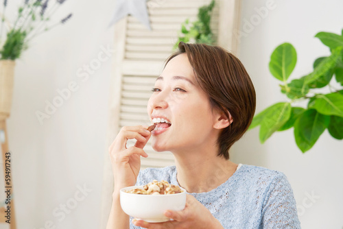 自宅でナッツを食べる女性