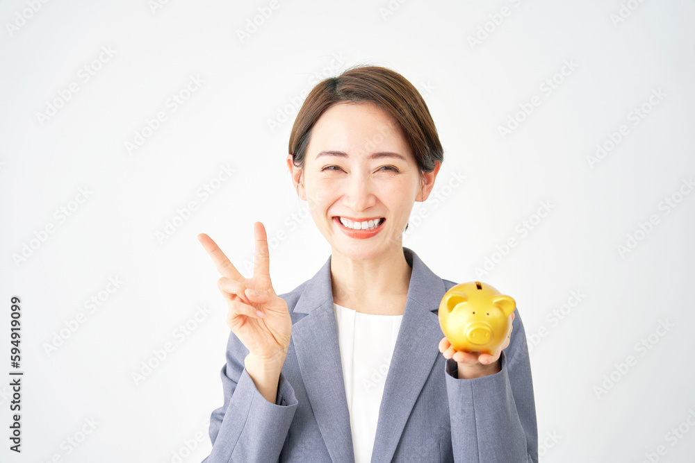貯金箱を持ってピースサインするビジネスウーマン　白背景