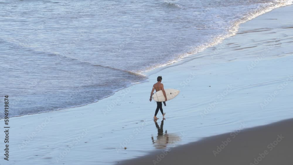 Anonymous Surfer walking on Atlantic Ocean Coast Sandy Beach in Morocco Anonymous Surfer walking on Atlantic Ocean Coast Sandy Beach in Morocco