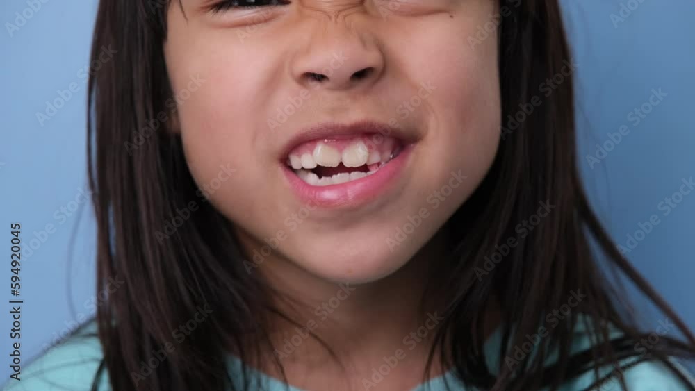 Cute little girl chewing gum on blue background. Portrait of a cute little girl enjoying eating chewing gum. Cute little girl chewing gum on blue background. Portrait of a cute little girl enjoying eating chewing gum.