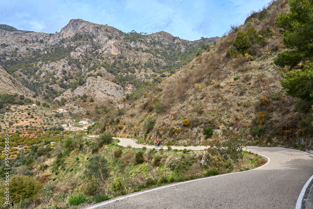 nice senior woman cycling with her electric mountain bike in the Sierra de Tejada near Nerja, Andalusia, Spain