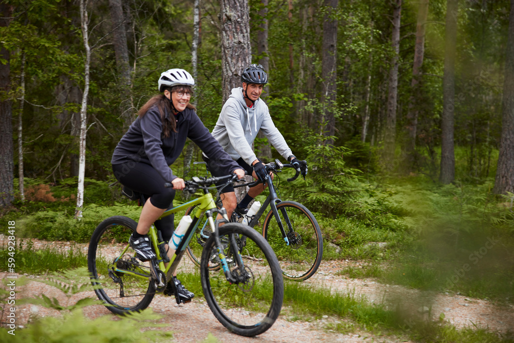 View of people cycling through forest View of people cycling through forest