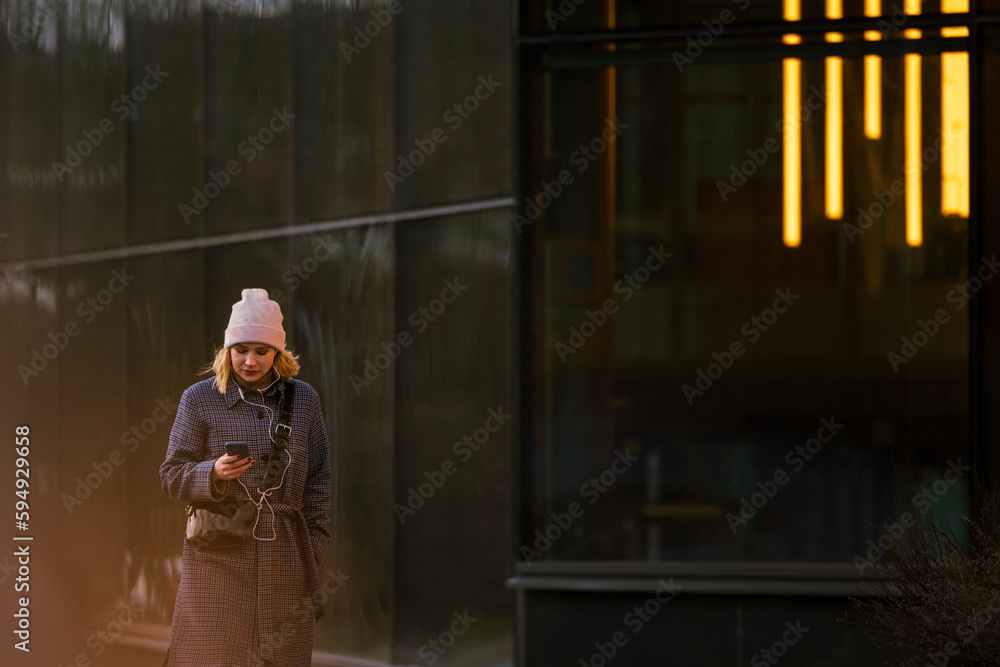 Young woman walking outdoors and using phone Young woman walking outdoors and using phone