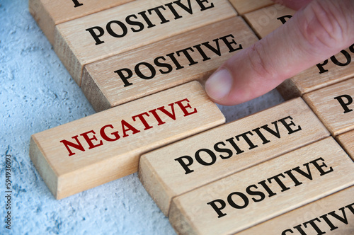 Fotografie Finger pushing negative text on wooden block from the rest of the wooden blocks with positive text