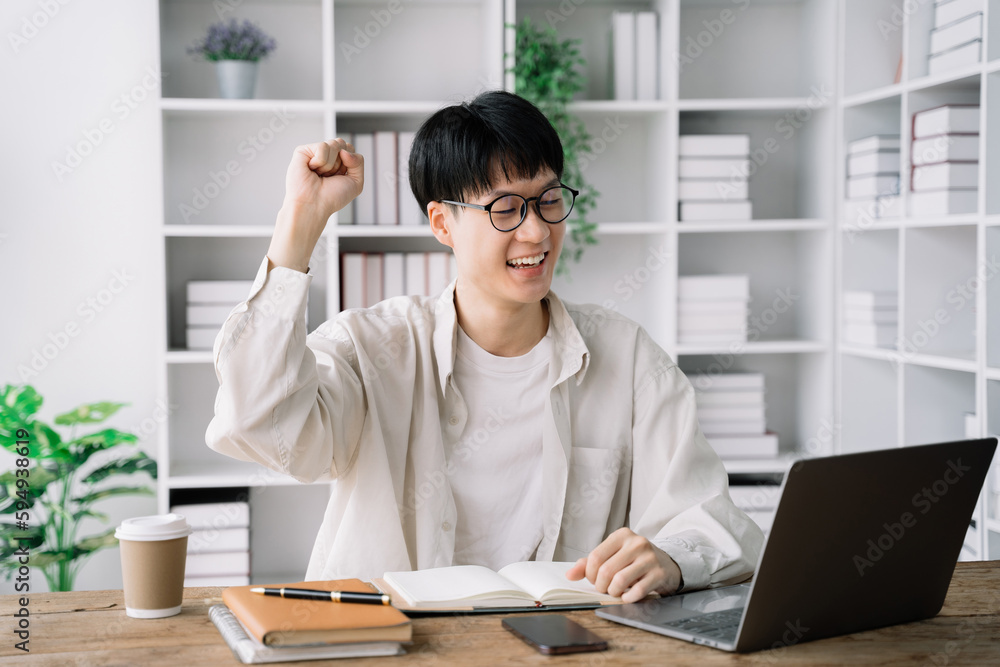 Happy student male says yes, passed an important test, raises hand with fist in excitement, smiles sincerely. Happy student male says yes, passed an important test, raises hand with fist in excitement, smiles sincerely.