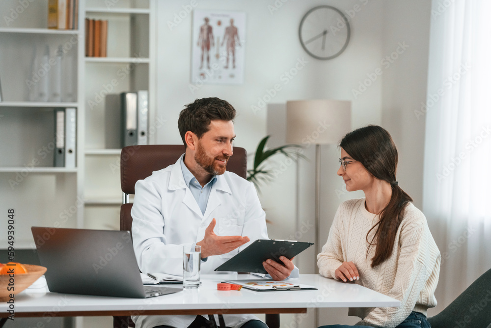 Conception of healthy eating. With woman. Doctor in formal clothes is working in the cabinet Conception of healthy eating. With woman. Doctor in formal clothes is working in the cabinet
