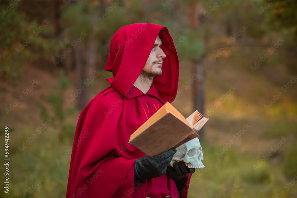 Φωτογραφία A sorcerer in red clothes with a skull and a book in his hands reads a spell