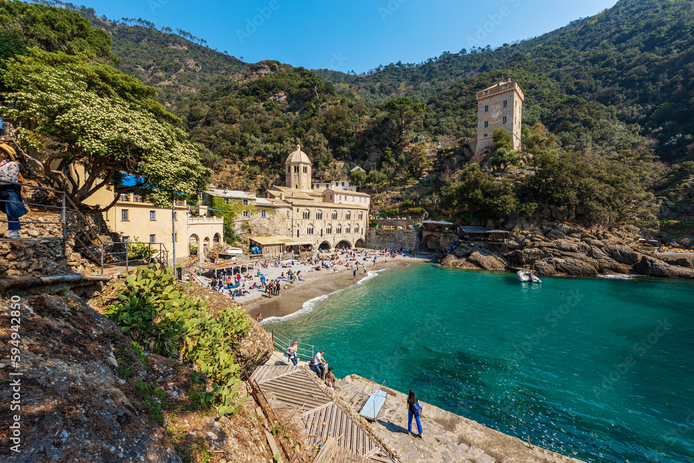 Φωτογραφία Ancient San Fruttuoso Abbey, X-XI century and the ancient Andrea Doria tower (Torre Andrea Doria, 1562), beach crowded with tourists near Portofino and Camogli, Genoa, Liguria, Italy, Europe