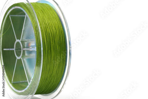 Braided green line for fishing on a transparent coil, isolate, close-up