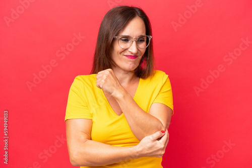Middle-aged caucasian woman isolated on red background with pain in elbow