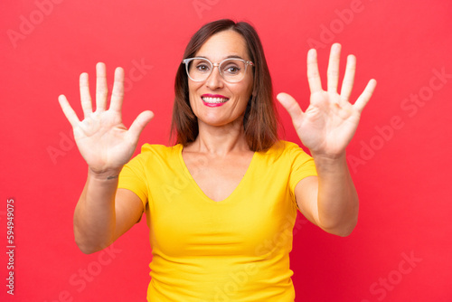 Middle-aged caucasian woman isolated on red background counting ten with fingers